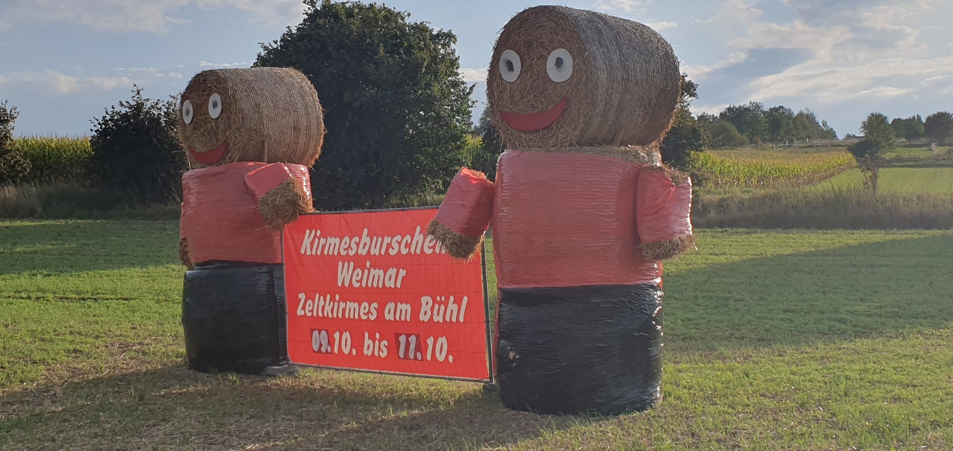 Zwei Strohballen-Figuren mit rotem Banner: Kirmesburschen Weimar, Zeltkirmes am Bühl 09.10. bis 11.10.